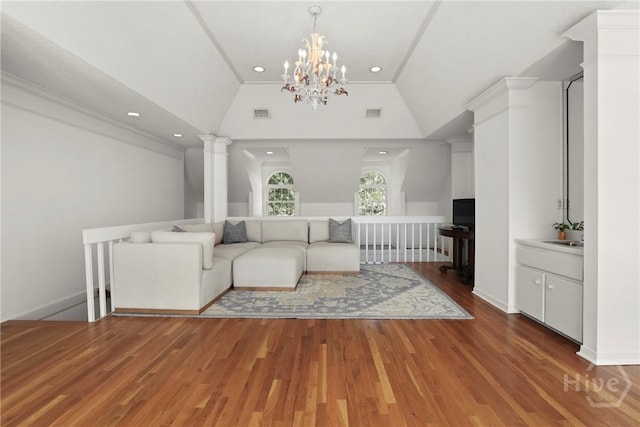 271 Davis Rd, Richmond Hill, GA 31324 - living room with vaulted ceiling, wood finished floors, ornate columns, a chandelier, and recessed lighting
