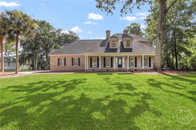271 Davis Rd, Richmond Hill, GA 31324 - cape cod-style house featuring a chimney, a front yard, a porch, and brick siding