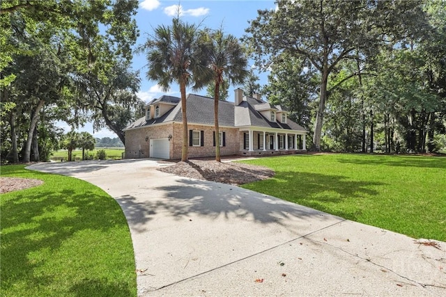 271 Davis Rd, Richmond Hill, GA 31324 - cape cod home featuring concrete driveway, a garage, a front lawn, brick siding, and a porch