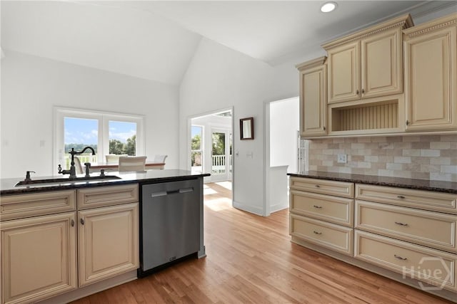 271 Davis Rd, Richmond Hill, GA 31324 - kitchen featuring cream cabinetry, stainless steel dishwasher, lofted ceiling, dark stone counters, and decorative backsplash