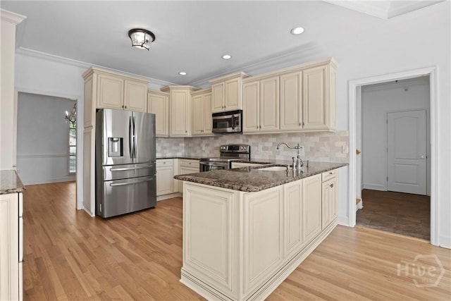 271 Davis Rd, Richmond Hill, GA 31324 - kitchen featuring stainless steel appliances, cream cabinetry, a peninsula, dark stone countertops, and tasteful backsplash