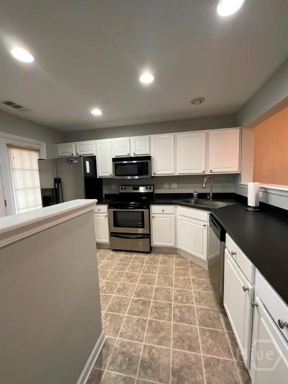 230 Opus Ct, Pooler, GA 31322 - kitchen featuring stainless steel appliances, white cabinets, recessed lighting, dark countertops, and light tile patterned flooring