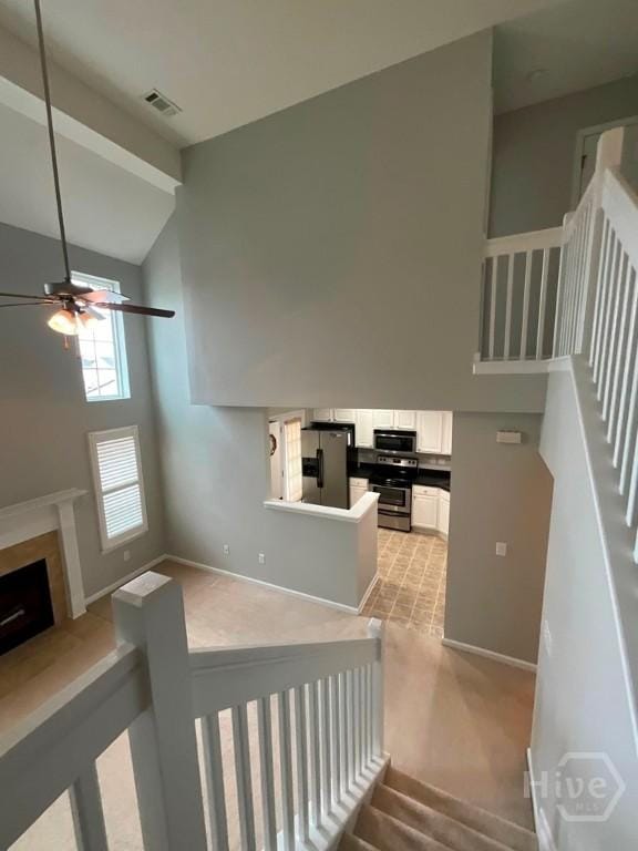 230 Opus Ct, Pooler, GA 31322 - staircase featuring high vaulted ceiling, carpet, a ceiling fan, and a fireplace with raised hearth