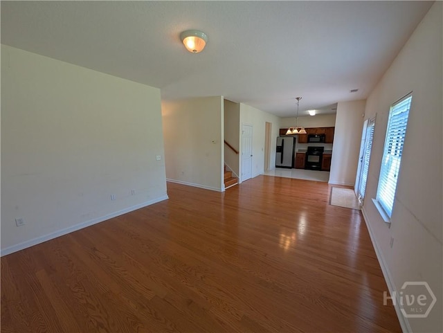 10 Evergreen Oak Dr, Richmond Hill, GA 31324 - unfurnished living room with light wood-style flooring and stairway