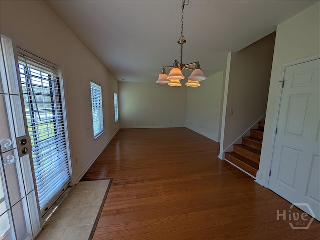 10 Evergreen Oak Dr, Richmond Hill, GA 31324 - unfurnished dining area featuring a chandelier, light wood finished floors, and stairs