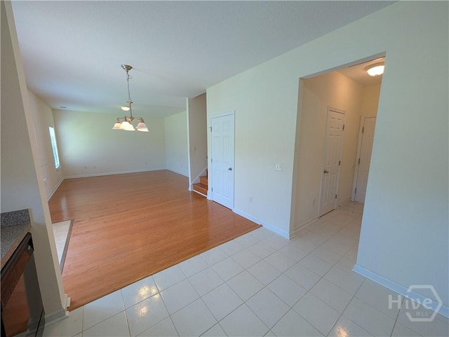 10 Evergreen Oak Dr, Richmond Hill, GA 31324 - spare room featuring stairway, light tile patterned floors, and a chandelier