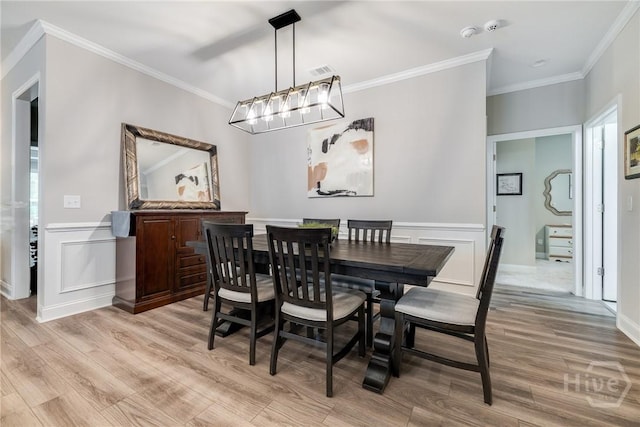 139 Harvest Hl, Pooler, GA 31322 - dining space with light wood-type flooring, crown molding, a decorative wall, and wainscoting