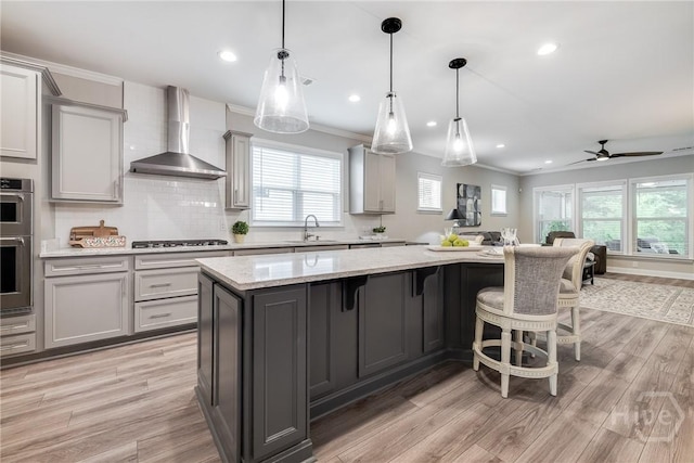139 Harvest Hl, Pooler, GA 31322 - kitchen with wall chimney range hood, gray cabinetry, a center island, light wood finished floors, and recessed lighting