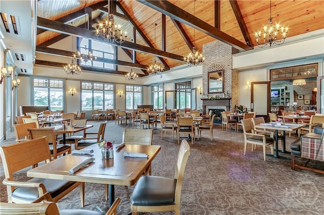 139 Harvest Hl, Pooler, GA 31322 - carpeted dining area with a chandelier, high vaulted ceiling, a wooden ceiling with exposed beams, plenty of natural light, and a fireplace