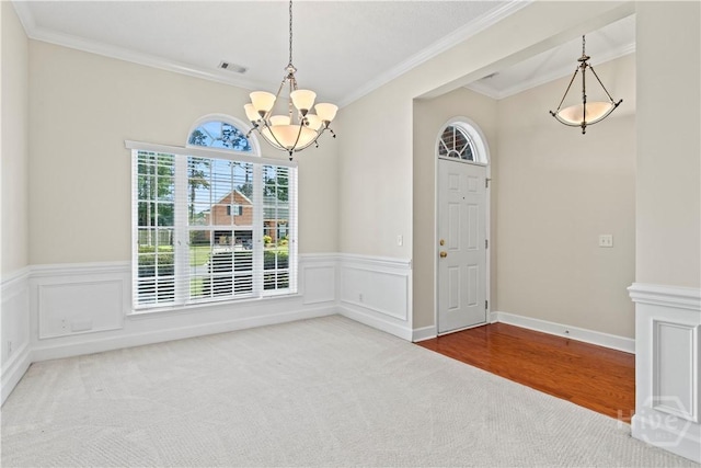 41 Patriot Dr, Richmond Hill, GA 31324 - unfurnished dining area with a chandelier, carpet flooring, crown molding, and wainscoting