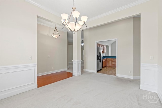 41 Patriot Dr, Richmond Hill, GA 31324 - empty room featuring a chandelier, ornamental molding, light colored carpet, and a wainscoted wall