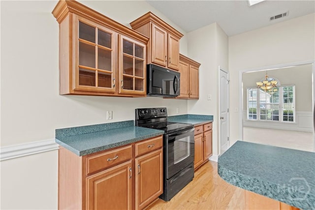 41 Patriot Dr, Richmond Hill, GA 31324 - kitchen with black appliances, a chandelier, glass insert cabinets, light wood-style floors, and dark countertops
