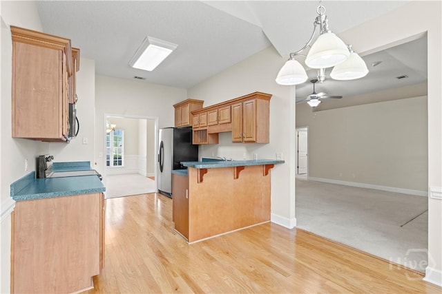 41 Patriot Dr, Richmond Hill, GA 31324 - kitchen with stainless steel appliances, a kitchen breakfast bar, a ceiling fan, and light wood-style flooring