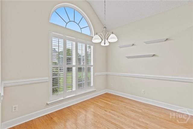 41 Patriot Dr, Richmond Hill, GA 31324 - empty room featuring a chandelier, wood finished floors, and vaulted ceiling