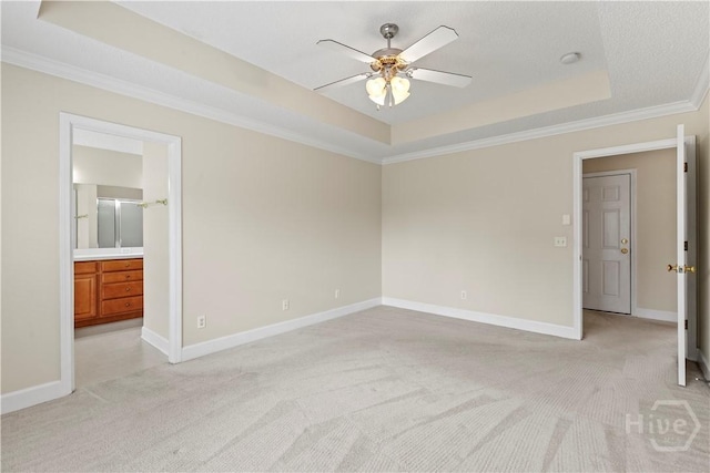 41 Patriot Dr, Richmond Hill, GA 31324 - unfurnished bedroom with a tray ceiling, light colored carpet, crown molding, connected bathroom, and a ceiling fan