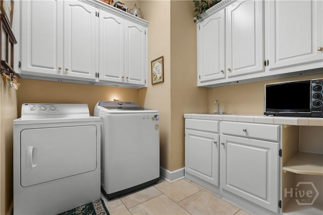 2055 Blankenbaker Rd, Statesboro, GA 30458 - laundry area with cabinet space, washer and clothes dryer, and light tile patterned floors