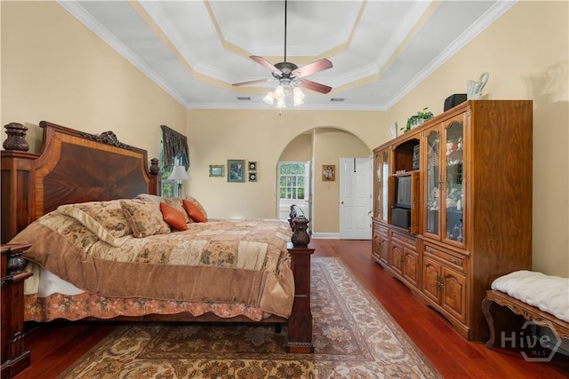 2055 Blankenbaker Rd, Statesboro, GA 30458 - bedroom with a tray ceiling, arched walkways, dark wood-style flooring, crown molding, and a ceiling fan