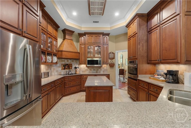 2055 Blankenbaker Rd, Statesboro, GA 30458 - kitchen with appliances with stainless steel finishes, custom range hood, backsplash, a tray ceiling, and glass insert cabinets
