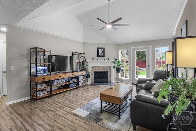 250 Laurel Hill Cir, Richmond Hill, GA 31324 - living room with ceiling fan, wood finished floors, a stone fireplace, and high vaulted ceiling