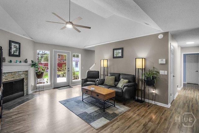 250 Laurel Hill Cir, Richmond Hill, GA 31324 - living area featuring vaulted ceiling, a ceiling fan, wood finished floors, and a stone fireplace