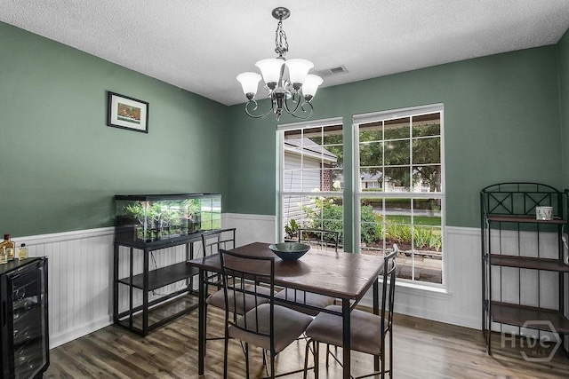 250 Laurel Hill Cir, Richmond Hill, GA 31324 - dining room with wainscoting, beverage cooler, a chandelier, a textured ceiling, and dark wood finished floors