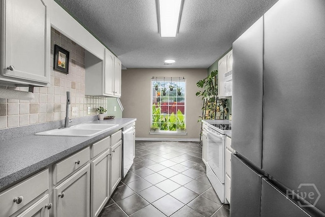250 Laurel Hill Cir, Richmond Hill, GA 31324 - kitchen with appliances with stainless steel finishes, a textured ceiling, dark tile patterned flooring, white cabinetry, and tasteful backsplash