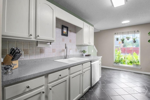 250 Laurel Hill Cir, Richmond Hill, GA 31324 - kitchen with dishwasher, a textured ceiling, backsplash, dark tile patterned flooring, and white cabinetry