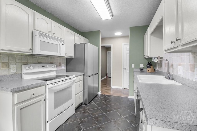 250 Laurel Hill Cir, Richmond Hill, GA 31324 - kitchen with white appliances, white cabinetry, backsplash, dark tile patterned floors, and a textured ceiling