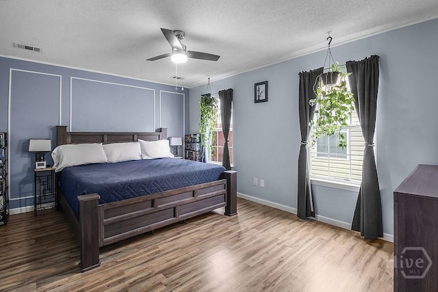 250 Laurel Hill Cir, Richmond Hill, GA 31324 - bedroom with wood finished floors, a textured ceiling, ornamental molding, and a ceiling fan