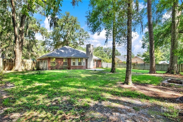 716 Greenwich Dr, Richmond Hill, GA 31324 - rear view of house with a chimney, a fenced backyard, and brick siding
