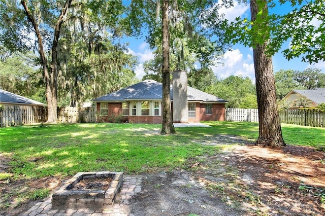 716 Greenwich Dr, Richmond Hill, GA 31324 - rear view of house featuring a chimney, a fenced backyard, brick siding, and a patio
