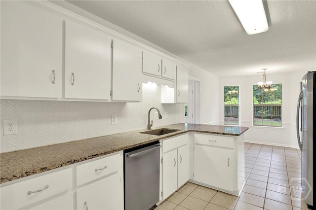 716 Greenwich Dr, Richmond Hill, GA 31324 - kitchen featuring appliances with stainless steel finishes, decorative backsplash, a peninsula, a textured ceiling, and white cabinets