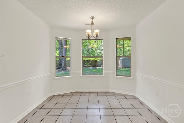 716 Greenwich Dr, Richmond Hill, GA 31324 - unfurnished room featuring healthy amount of natural light, a chandelier, a textured ceiling, and light tile patterned flooring