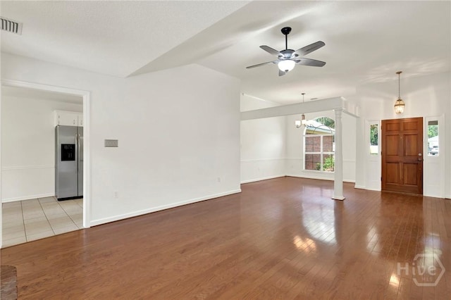 716 Greenwich Dr, Richmond Hill, GA 31324 - unfurnished living room with healthy amount of natural light, a ceiling fan, vaulted ceiling, wood finished floors, and decorative columns