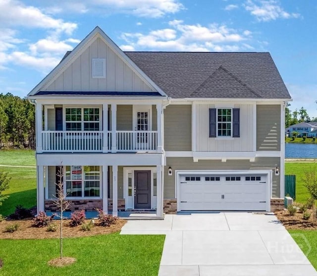 33 Spring Hill Dr, Richmond Hill, GA 31324 - view of front of house with board and batten siding, driveway, an attached garage, covered porch, and a front lawn