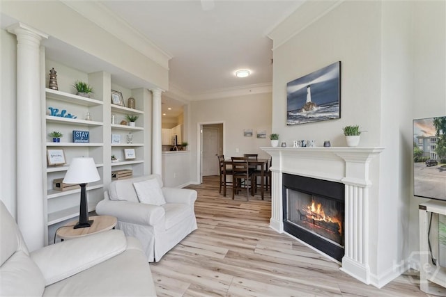 2536 Whitemarsh Way, Savannah, GA 31410 - living room with ornamental molding, light wood-style flooring, a glass covered fireplace, ornate columns, and built in shelves