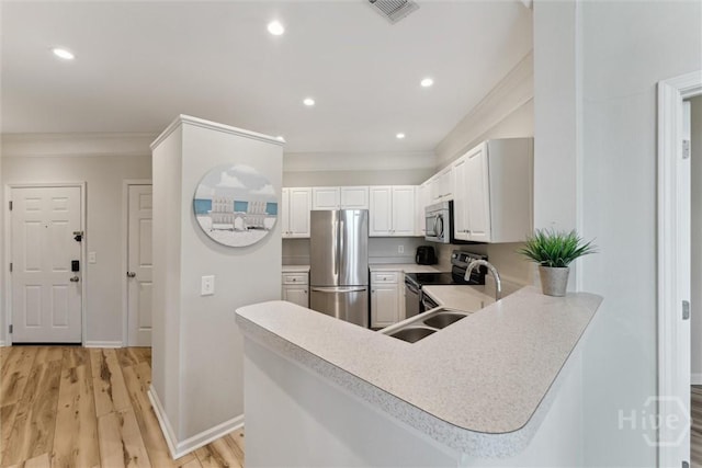 2536 Whitemarsh Way, Savannah, GA 31410 - kitchen featuring appliances with stainless steel finishes, crown molding, light countertops, white cabinets, and light wood finished floors