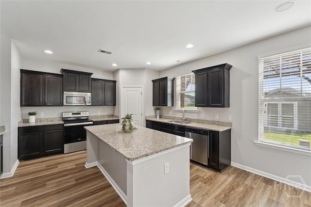 54 Winslow, Savannah, GA 31407 - kitchen with stainless steel appliances, light wood-style flooring, a kitchen island, recessed lighting, and light stone counters