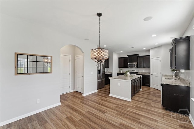 54 Winslow, Savannah, GA 31407 - kitchen featuring stainless steel appliances, a center island, arched walkways, light wood-type flooring, and recessed lighting