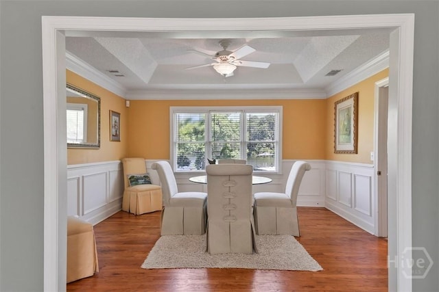114 Lakeview Ct, Savannah, GA 31406 - dining room with a raised ceiling, wood finished floors, ornamental molding, a wainscoted wall, and ceiling fan