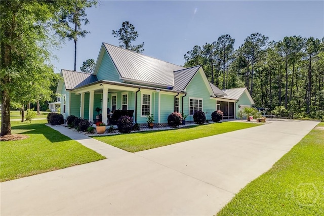 523 Goodman Dr, Midway, GA 31320 - view of front facade with a metal roof, a front yard, a porch, and driveway
