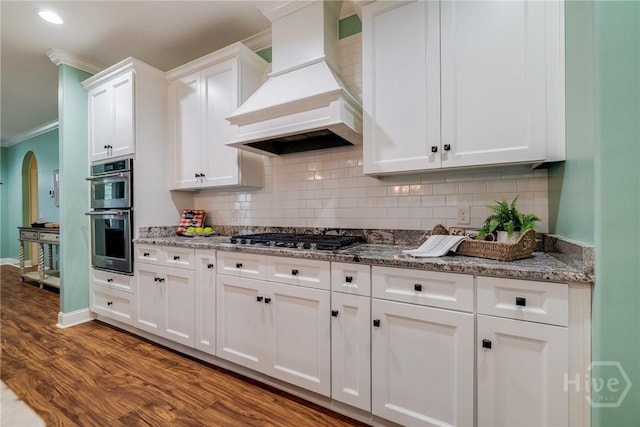 523 Goodman Dr, Midway, GA 31320 - kitchen featuring custom range hood, ornamental molding, white cabinets, backsplash, and dark wood-style flooring