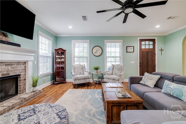 523 Goodman Dr, Midway, GA 31320 - living area with ornamental molding, a ceiling fan, wood finished floors, a brick fireplace, and arched walkways