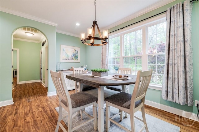 523 Goodman Dr, Midway, GA 31320 - dining space with a chandelier, plenty of natural light, crown molding, wood finished floors, and arched walkways