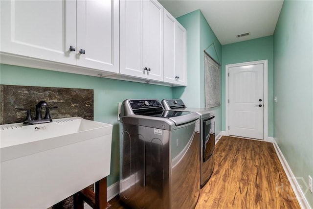 523 Goodman Dr, Midway, GA 31320 - laundry area with washer and dryer, wood finished floors, and cabinet space