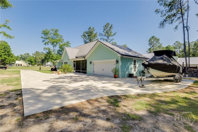 523 Goodman Dr, Midway, GA 31320 - view of home's exterior featuring an attached garage, driveway, and a metal roof