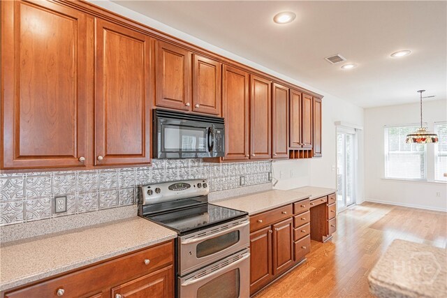 143 Regency Cir, Pooler, GA 31322 - kitchen featuring double oven range, black microwave, light wood-type flooring, brown cabinetry, and recessed lighting