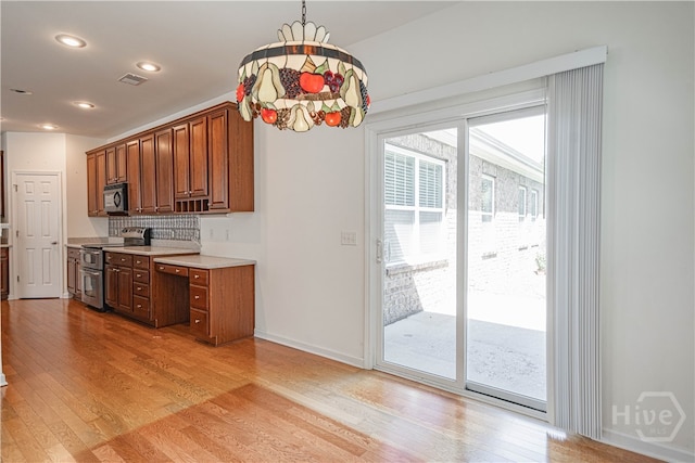 143 Regency Cir, Pooler, GA 31322 - kitchen with double oven range, light wood-style flooring, light countertops, backsplash, and brown cabinetry