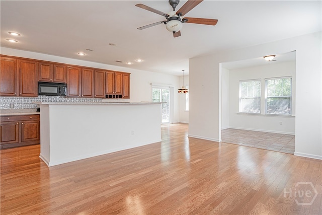 143 Regency Cir, Pooler, GA 31322 - kitchen with ceiling fan, brown cabinets, black microwave, and recessed lighting