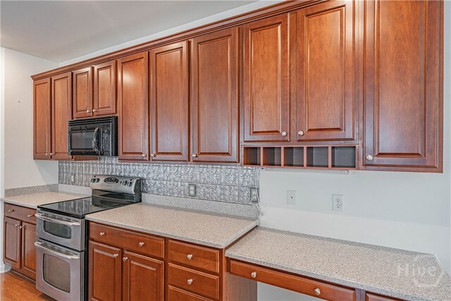 143 Regency Cir, Pooler, GA 31322 - kitchen featuring double oven range, black microwave, decorative backsplash, and brown cabinetry